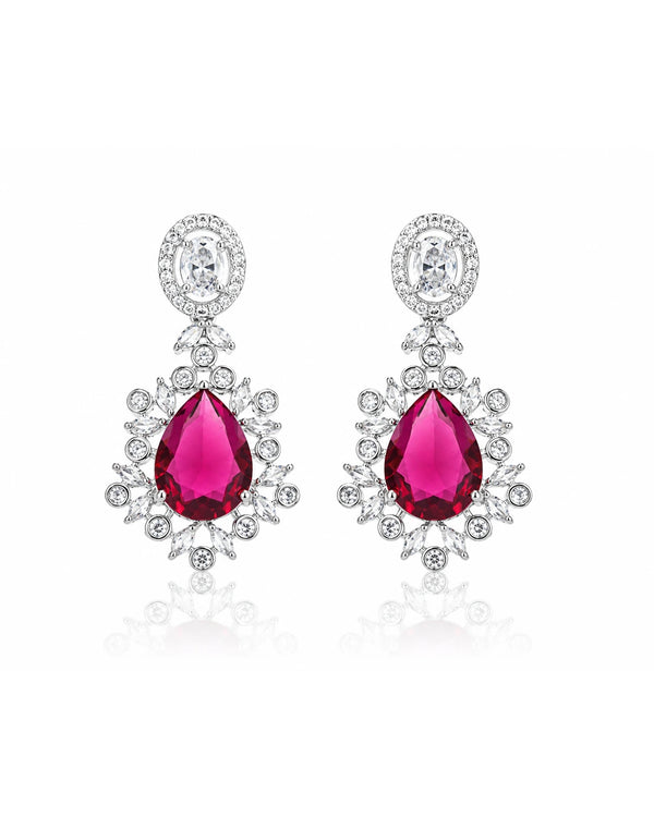 Pair of earrings with red gemstones and silver accents on a white background