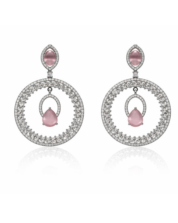 Pair of earrings with pink gemstones and circular designs on a white background