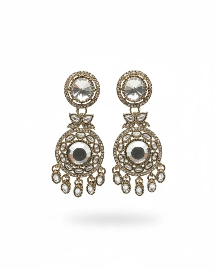Pair of ornate earrings with gemstones on a white background