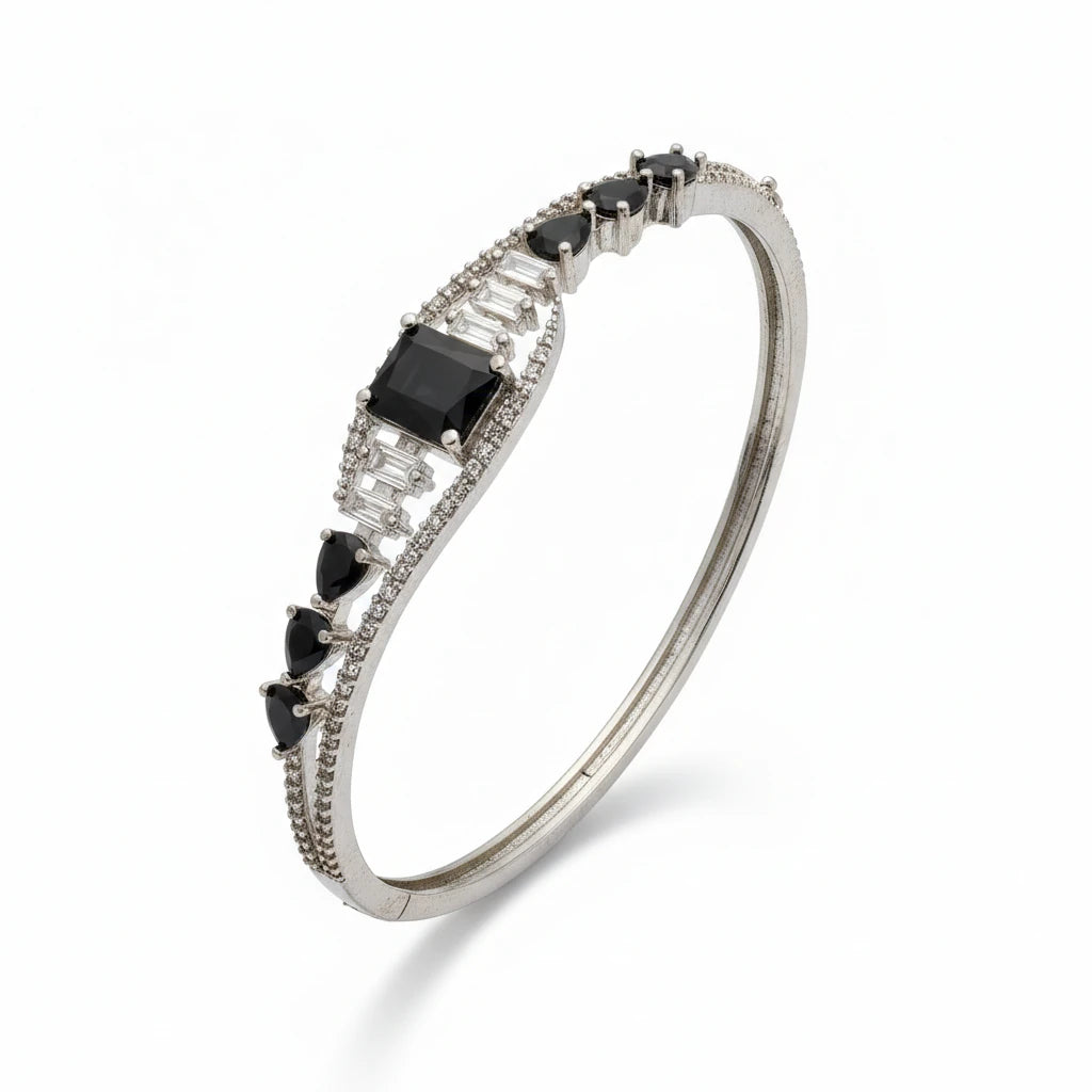 Silver bracelet with black and clear gemstones on a white background