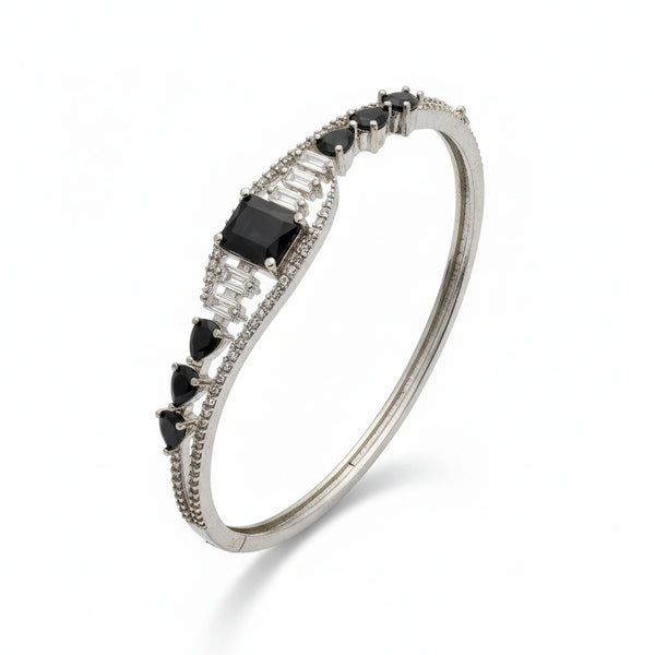 Silver bracelet with black and clear gemstones on a white background