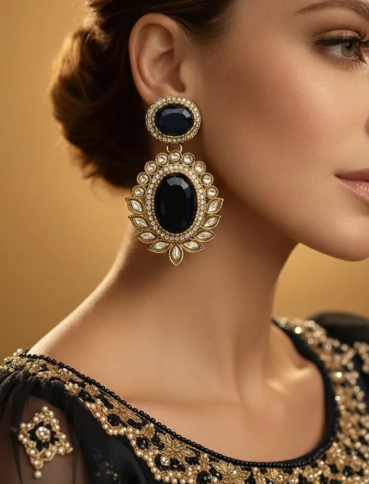 Close-up of a woman wearing ornate earrings with a gold and black embroidered garment.