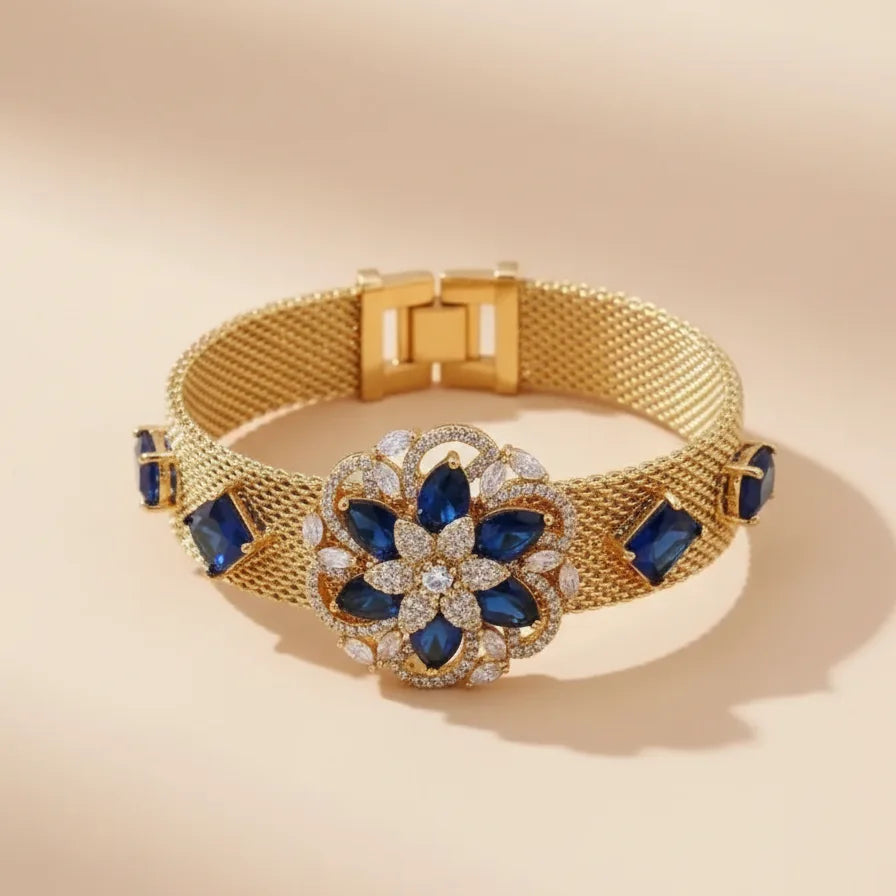 Gold bracelet with blue gemstones on a beige background