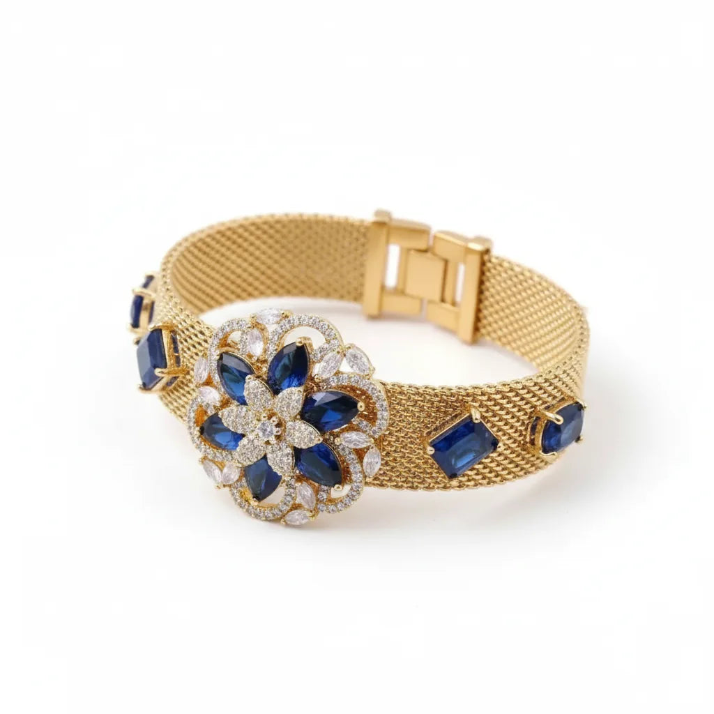 Gold bracelet with blue gemstones on a white background