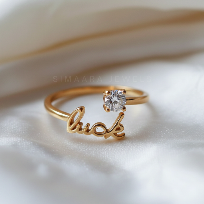 Gold ring with 'luck' engraving and diamond on a soft fabric background