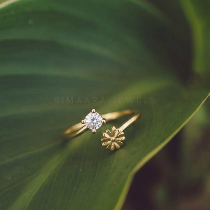 Gold ring with a diamond on a green leaf, featuring 'Simaara Jewels' branding.