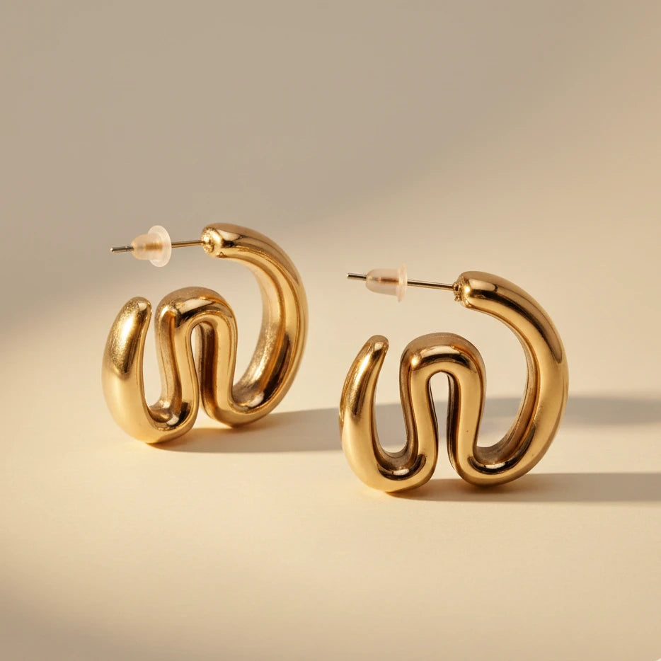 Gold hoop earrings on a beige background