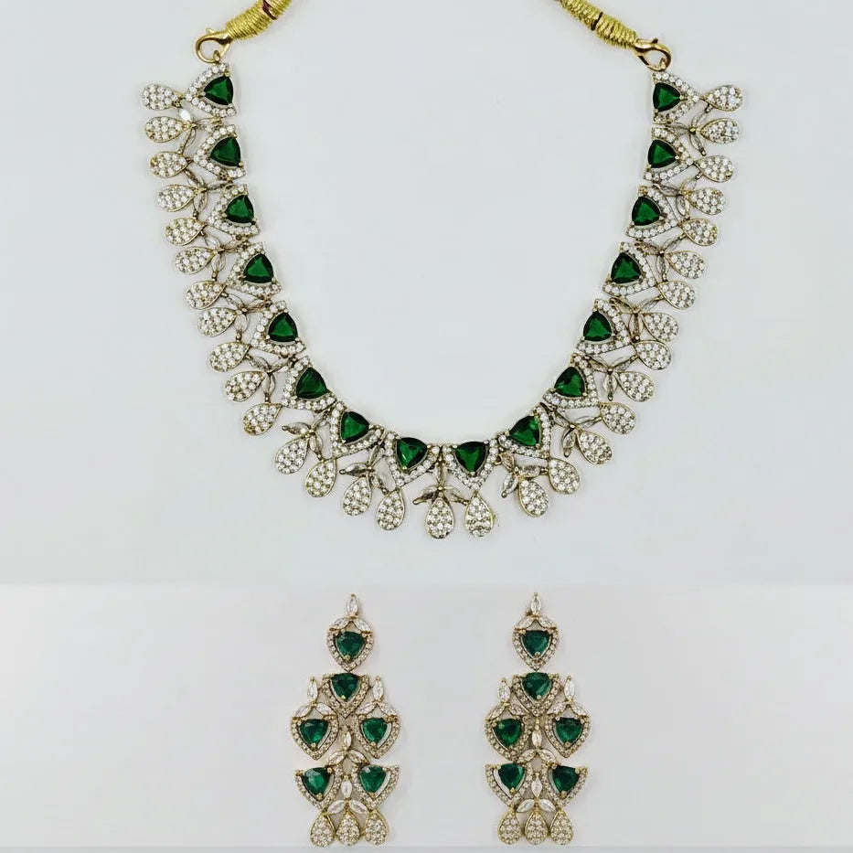Jewelry set with necklace and earrings featuring green gemstones on a white background