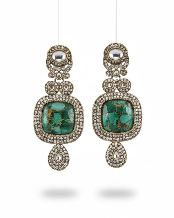 Pair of earrings with turquoise stones and decorative elements on a white background