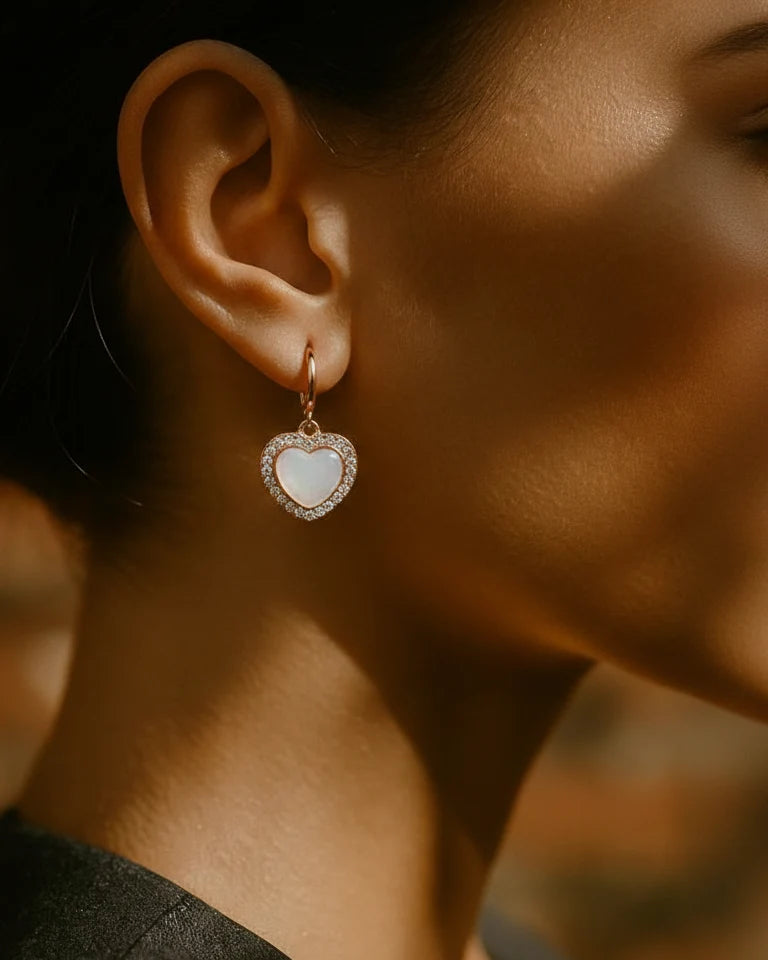 Heart-shaped earring worn by a person with a blurred background