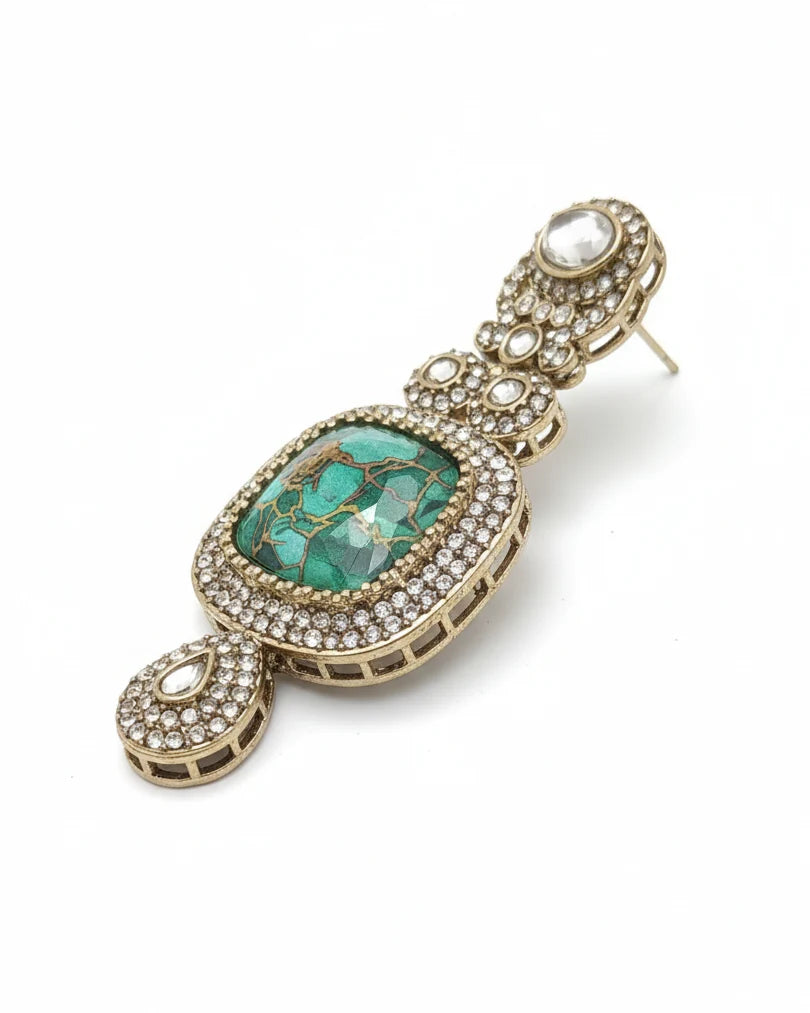 Jewelry earring with green gemstone and gold accents on a white background