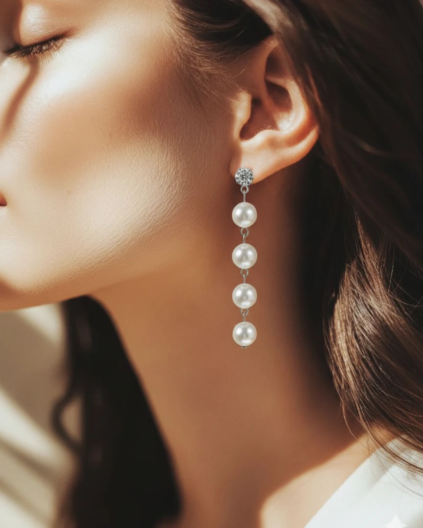 Close-up of a woman wearing pearl earrings with a blurred background