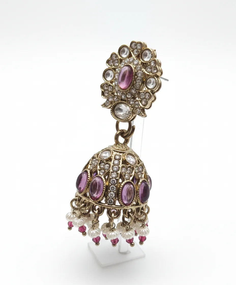 Ornate earring with pink gemstones and pearl-like elements on a white background
