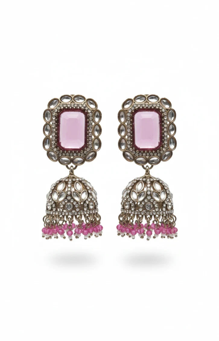 Pair of earrings with pink stones and dangling elements on a white background