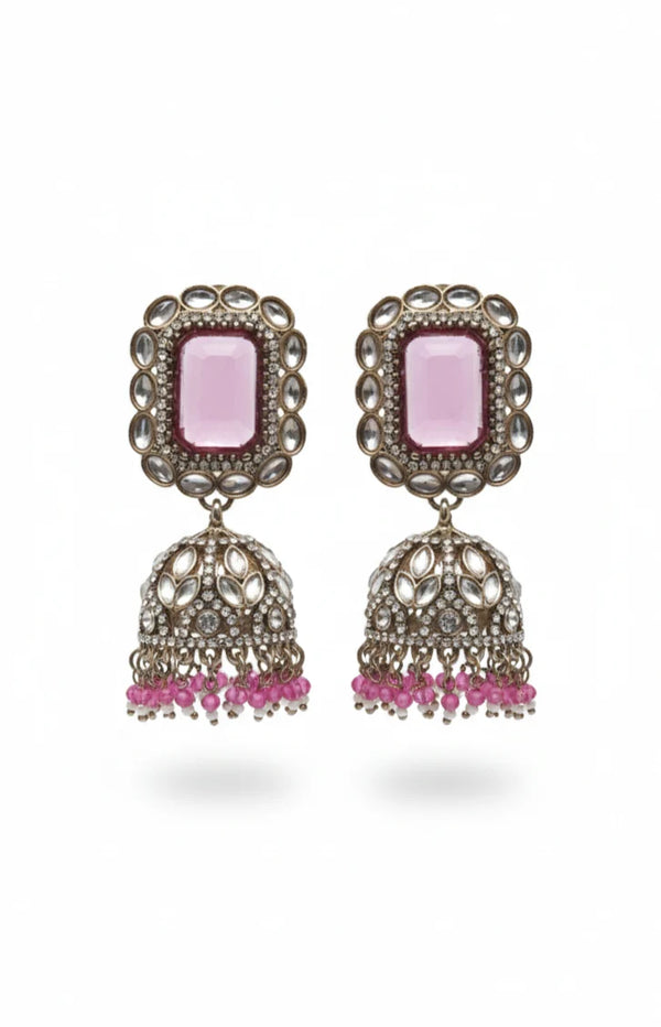 Pair of earrings with pink stones and dangling elements on a white background