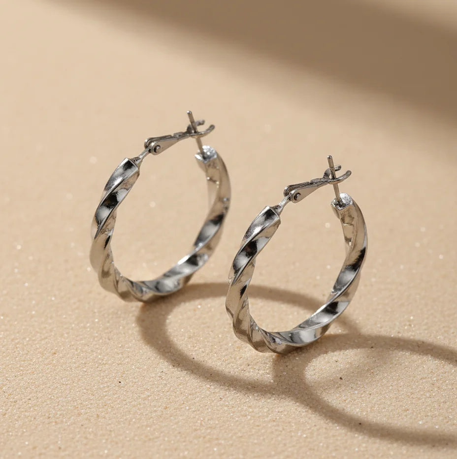 Silver hoop earrings on a beige background