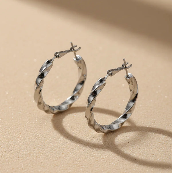 Silver hoop earrings on a beige background