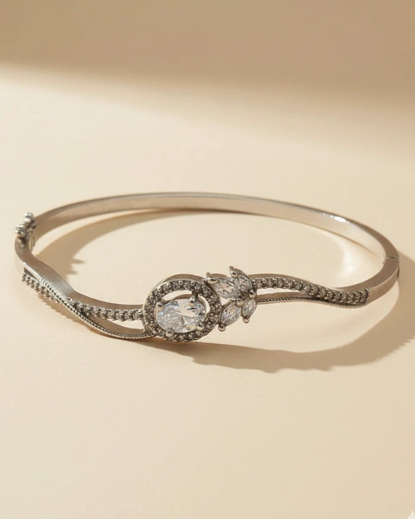 Silver bracelet with a central gemstone on a beige background