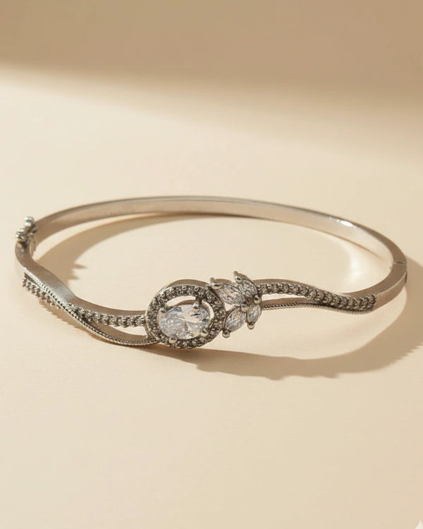 Silver bracelet with a central gemstone on a beige background