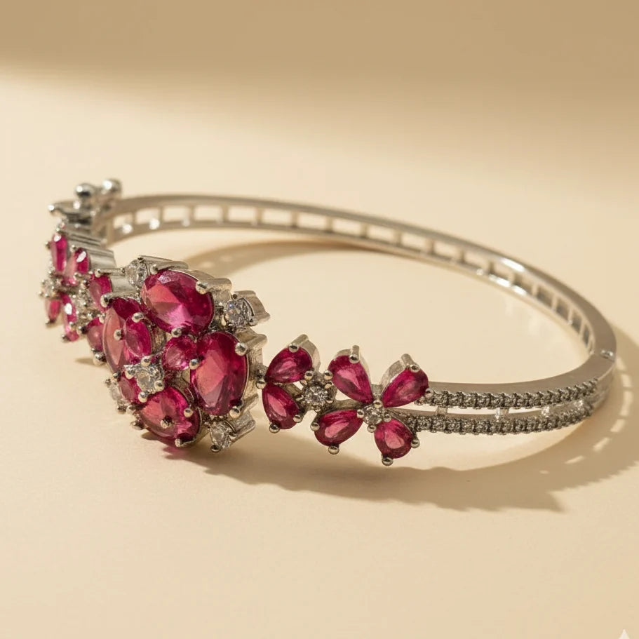Silver bracelet with red gemstones on a beige background