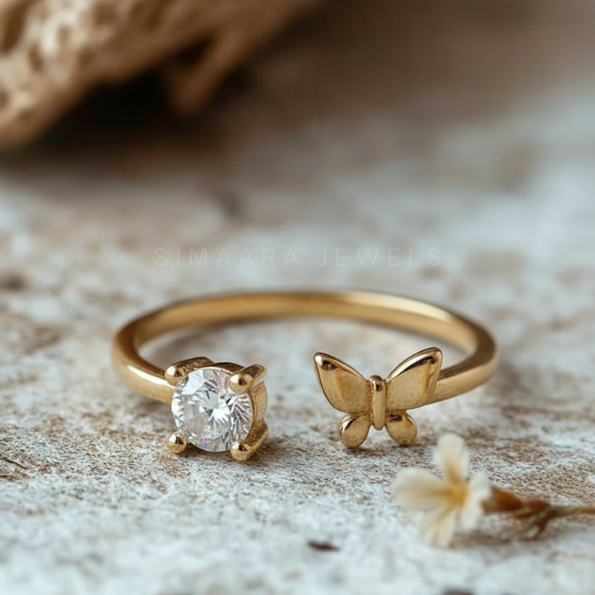 Golden ring with diamond and butterfly design on a textured surface