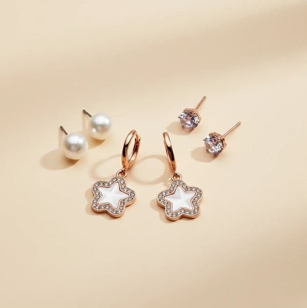 Star-shaped earrings with rose gold frames on a beige background