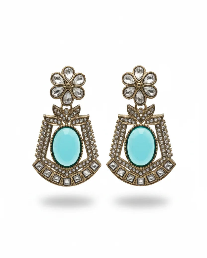 Pair of ornate earrings with turquoise stones on a white background
