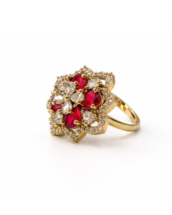 Gold ring with red gemstones and clear stones on a white background