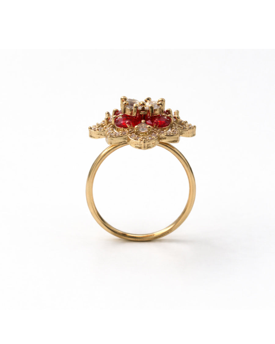 Gold ring with red gemstones on a white background