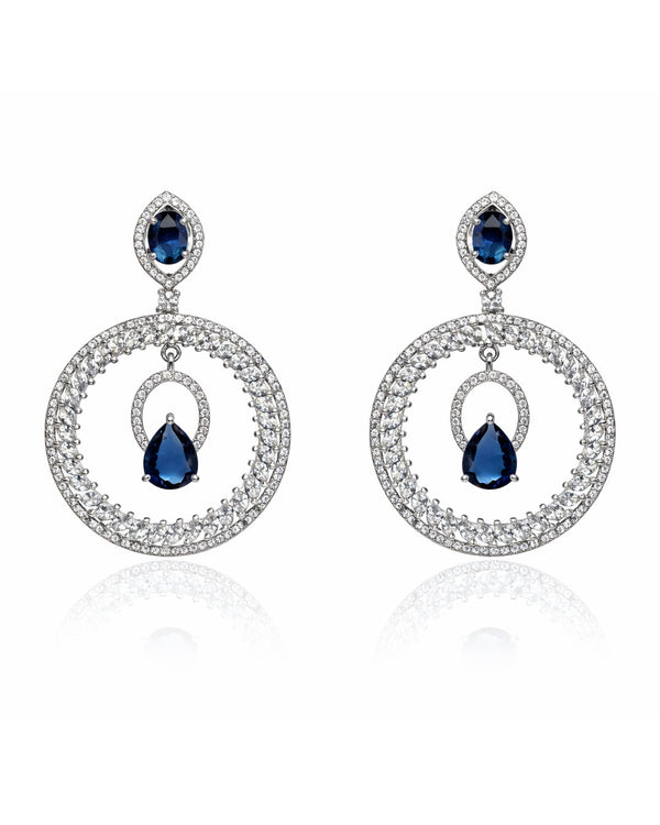 Pair of earrings with blue gemstones and silver circular designs on a white background