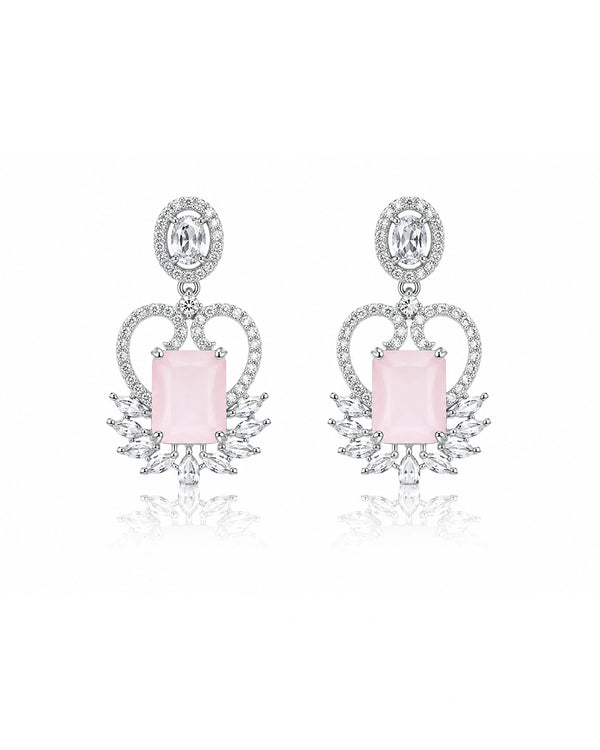 Pair of earrings with pink gemstones and diamond-like elements on a white background