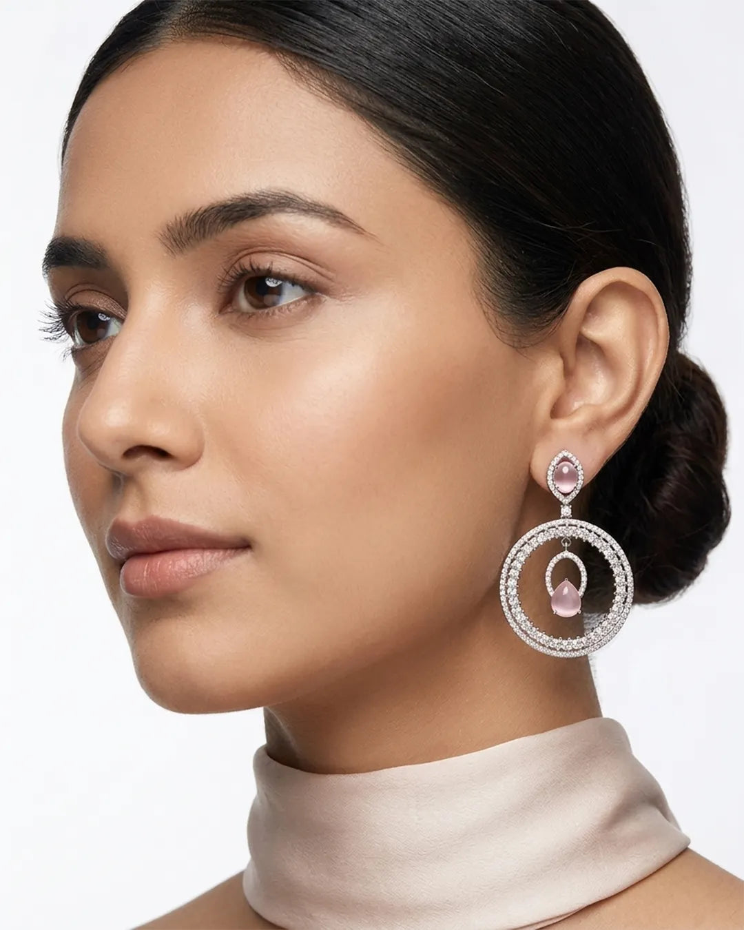Woman wearing a pair of earrings with a soft focus background