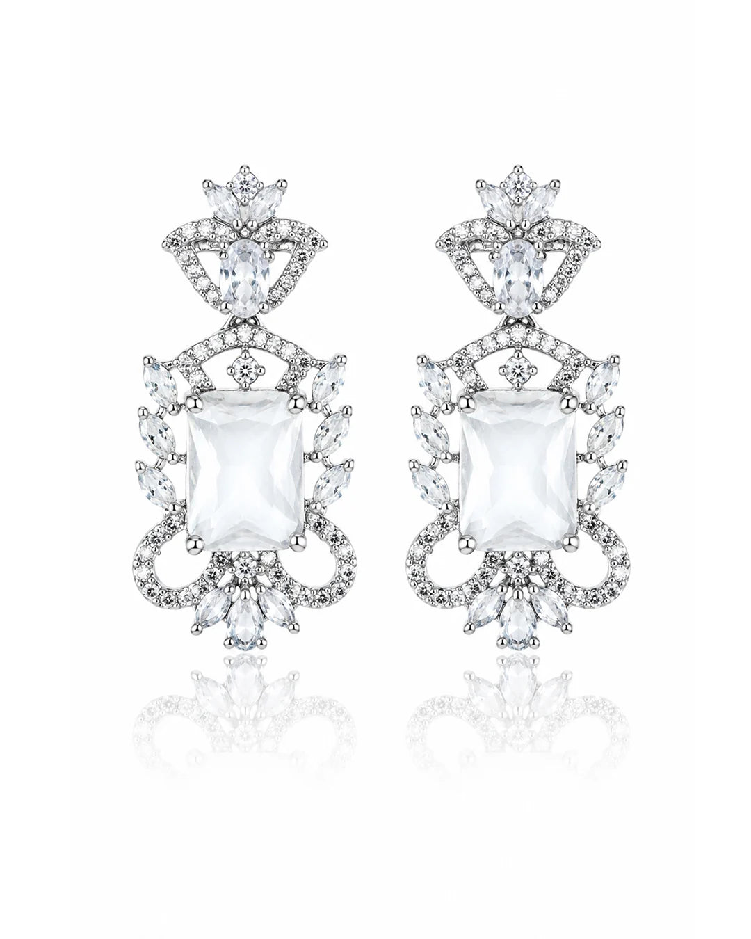 Pair of ornate earrings with clear gemstones on a white background