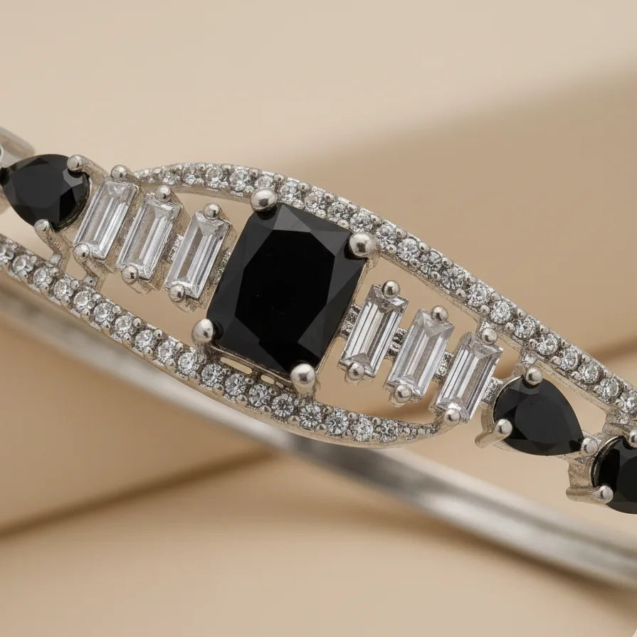 Elegant bracelet with black gemstones and diamonds on a beige background