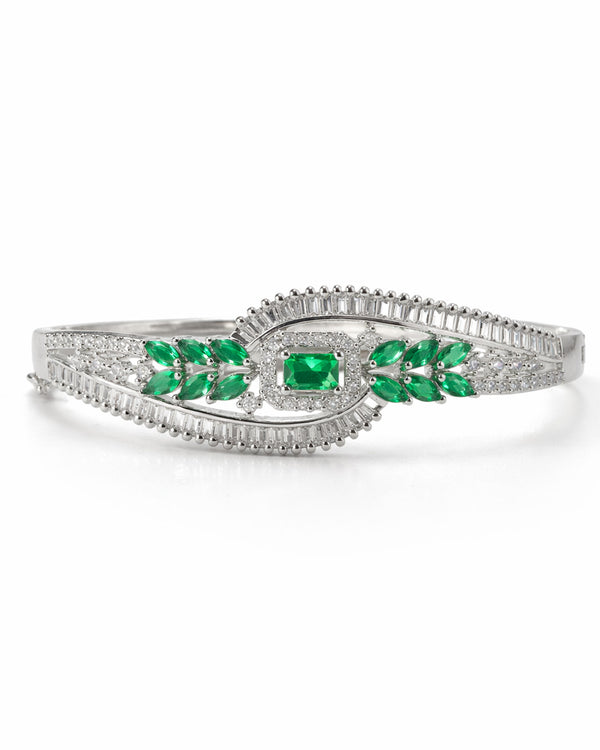 Silver bracelet with green gemstones on a white background