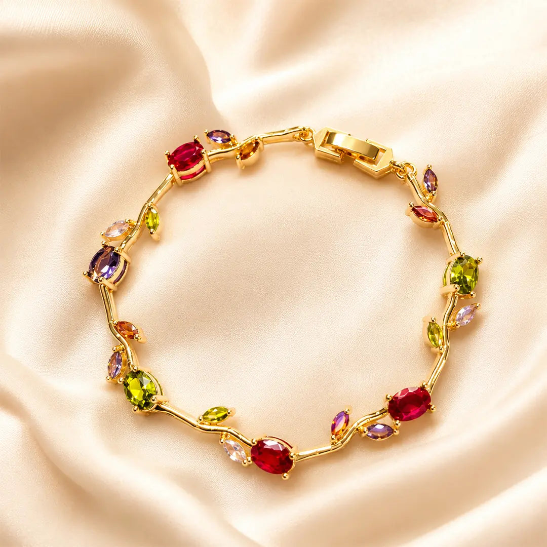 Gold bracelet with colorful gemstones on a beige satin background