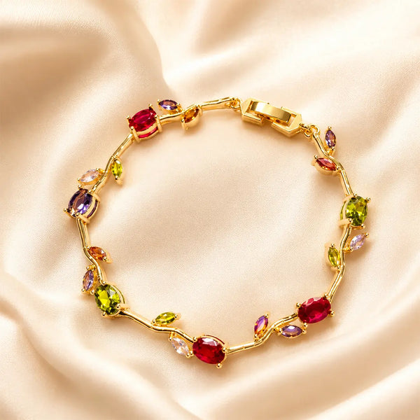 Gold bracelet with colorful gemstones on a beige satin background