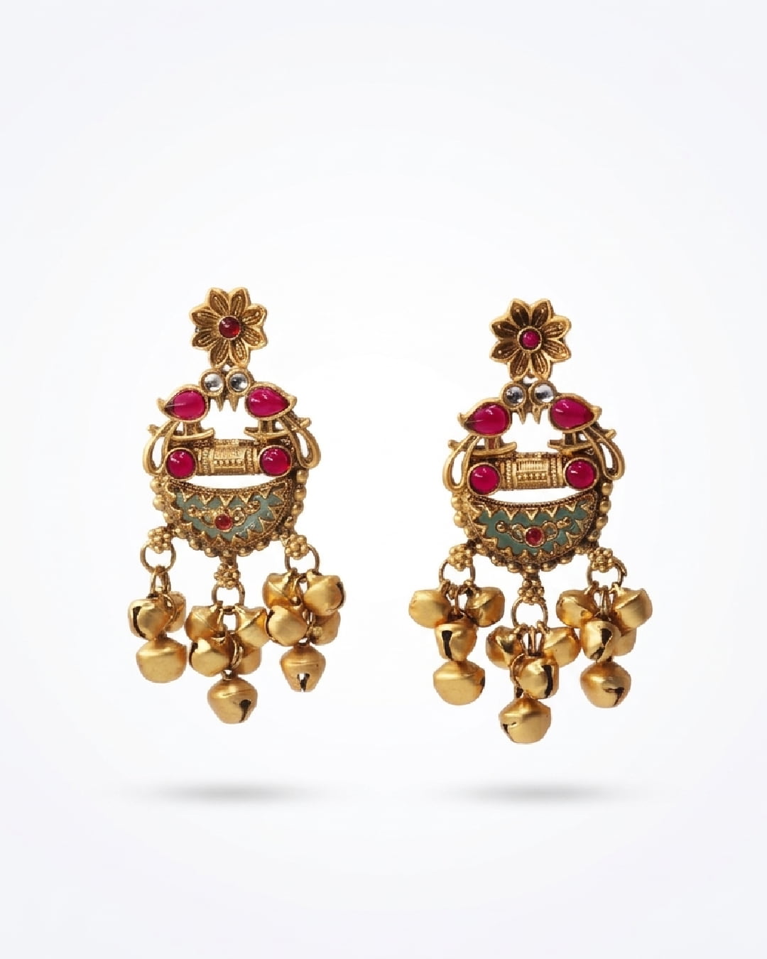 Golden earrings with red gemstones on a white background