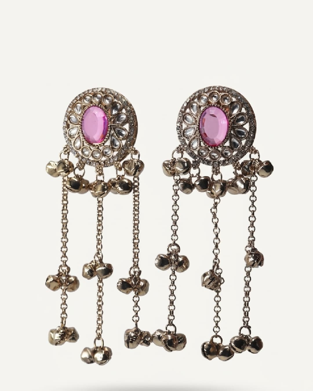 Ornate earrings with pink gemstones on a white background