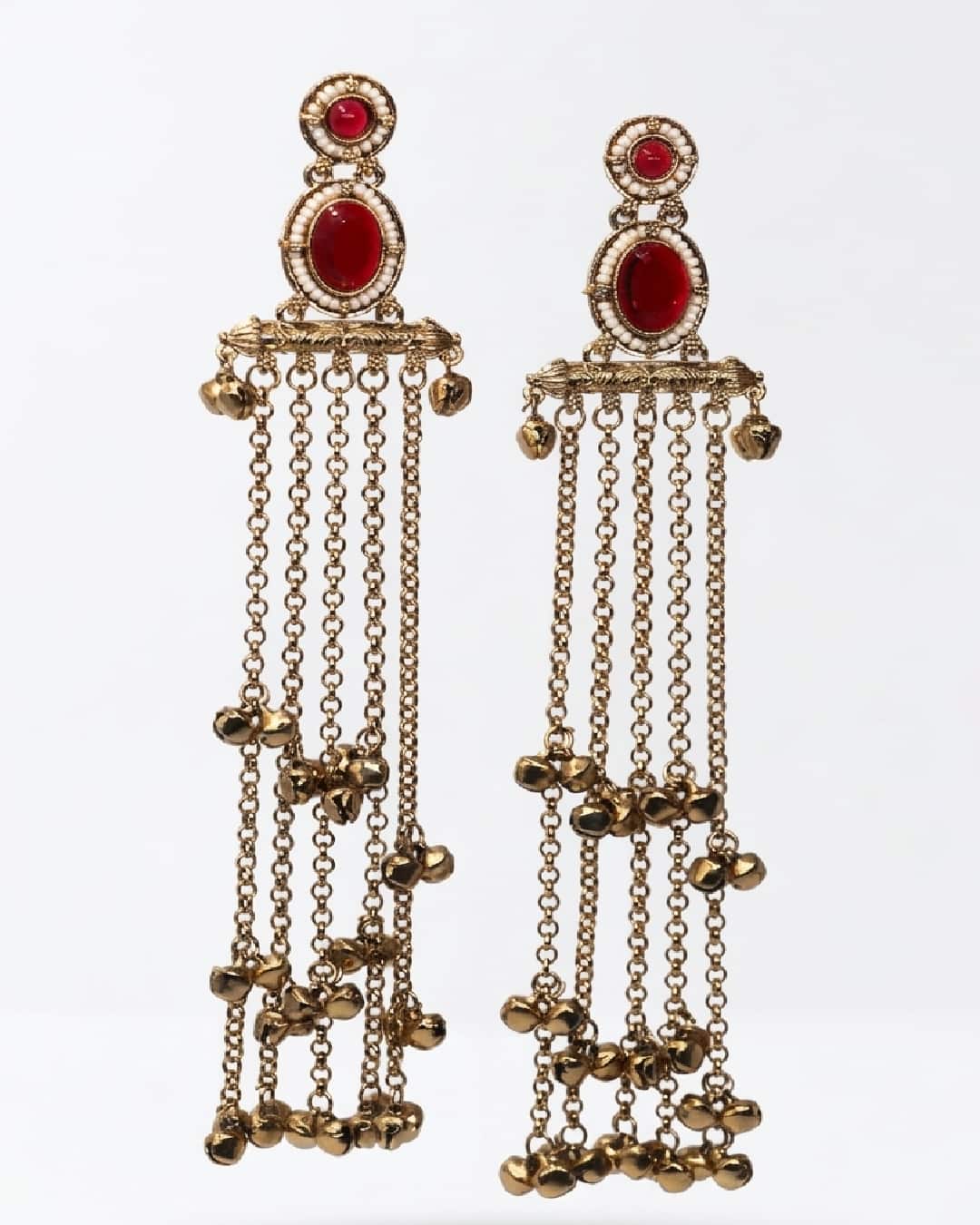 Gold earrings with red gemstones and hanging chains on a white background