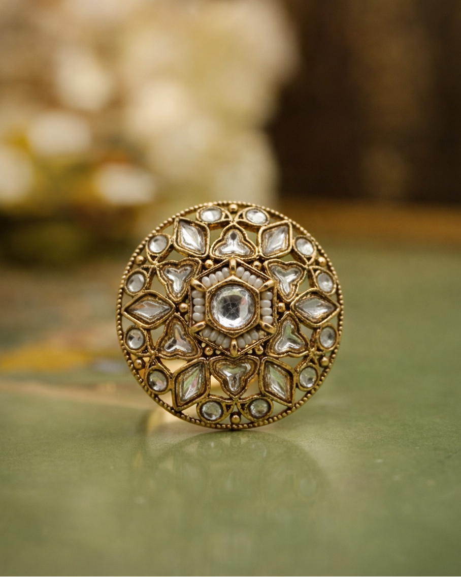 Decorative ring with intricate design on a green surface