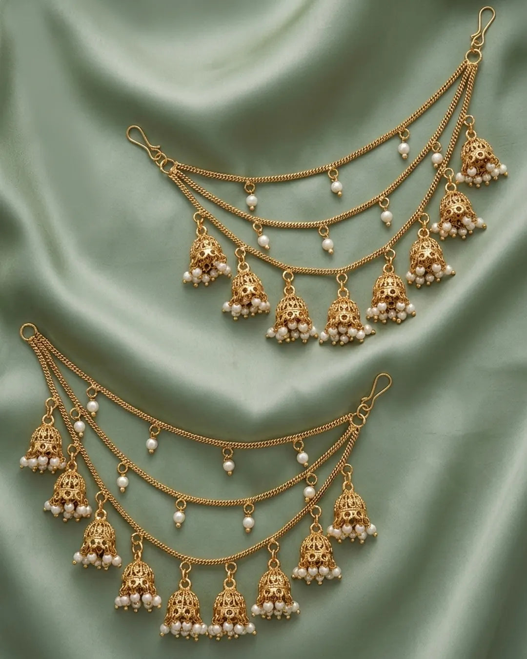 Gold and pearl jewelry set on a green fabric background