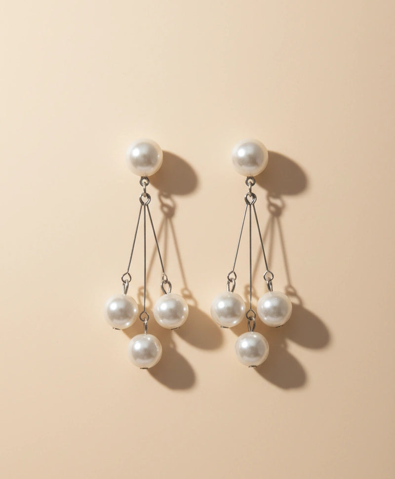 Pair of pearl earrings on a beige background