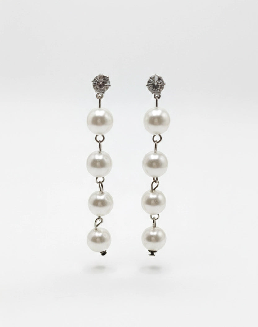 Pair of pearl earrings with silver clasps on a white background