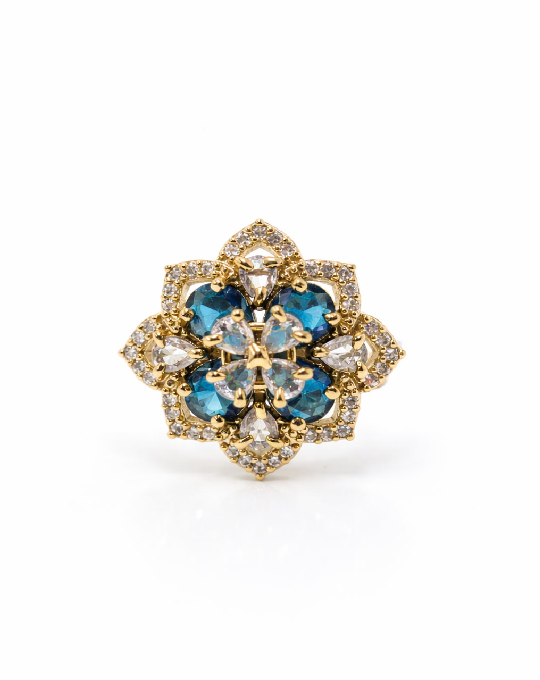 Gold and blue gemstone brooch on a white background
