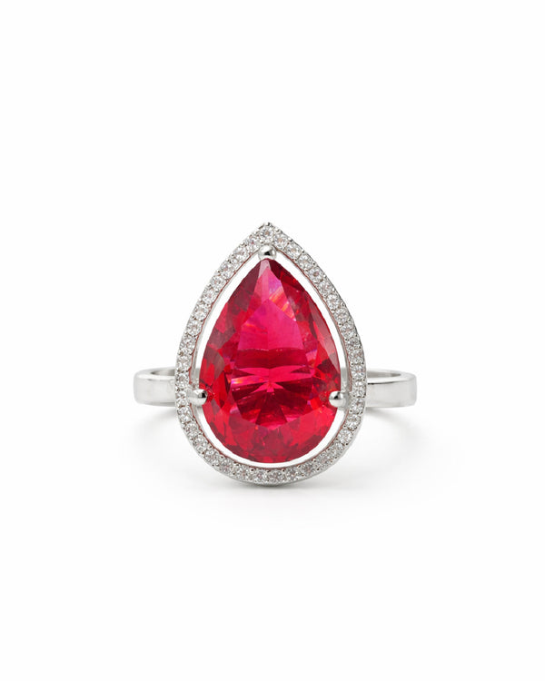 Ring with a red teardrop-shaped gemstone on a white background