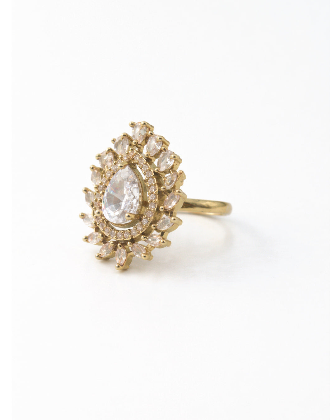 Gold ring with a large central gemstone and smaller stones on a white background