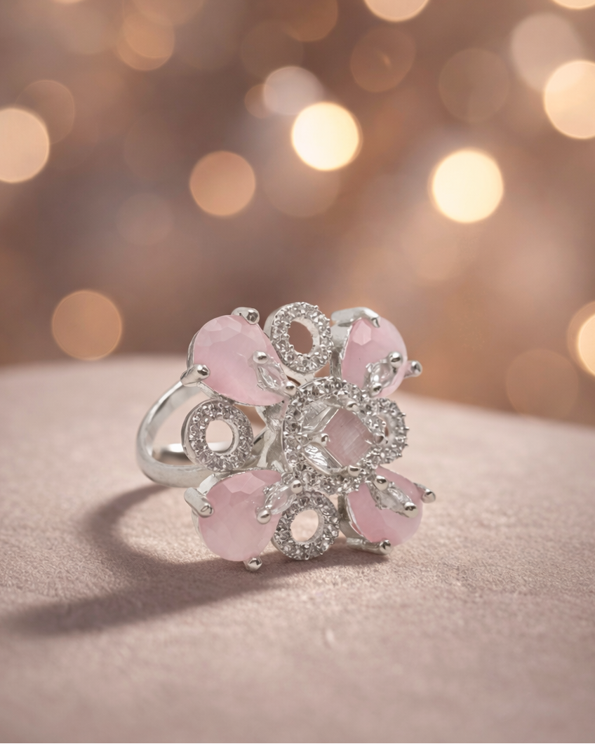 Silver ring with pink gemstones on a soft focus background