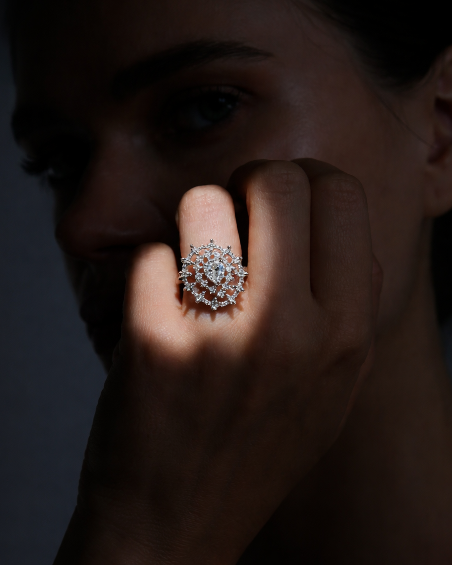 Close-up of a hand wearing a silver ring with a dark background