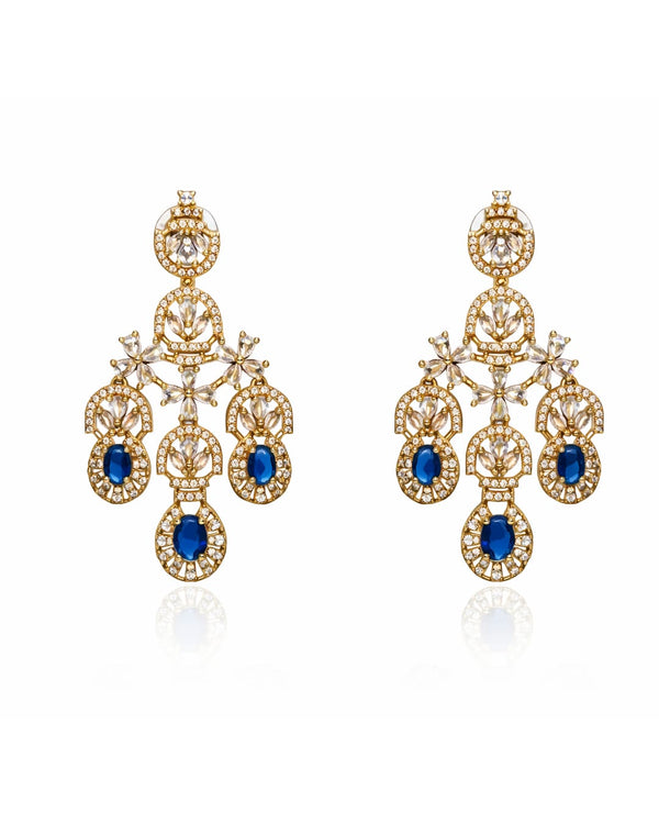 Gold earrings with blue gemstones on a white background